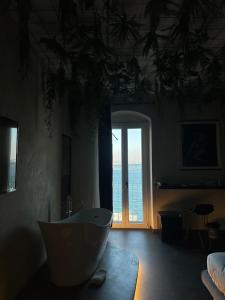 a living room with a tub and a large window at Sonrisa Suites in Taranto