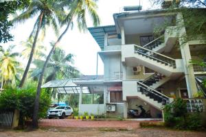 a building with stairs and a car parked in front of it at Wayne Nest Calangute in Calangute +5 photos