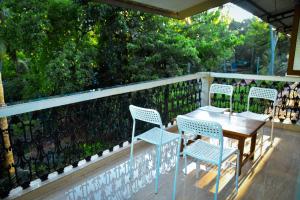 a table and chairs on a balcony with a fence at Wayne Nest Calangute in Calangute