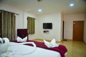 a hotel room with two beds with white pillows at Wayne Nest Calangute in Calangute