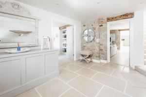 a bathroom with white walls and a stone wall at The Tide House in St Ives +64 photos