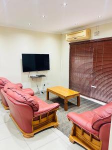 a living room with two couches and a tv at Langelihle- Margate Accommodation in Margate