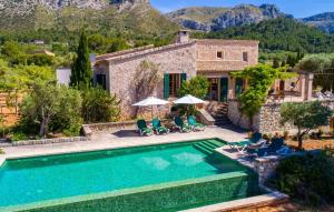a villa with a swimming pool in front of a house at Villa Maria De Betlem in Colonia de Sant Pere