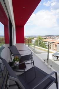 a balcony with chairs and a view of the city at Casa do Pessegueiro in Mirandela