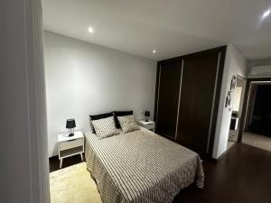 a bedroom with a bed and two tables and a cabinet at Casa do Pessegueiro in Mirandela