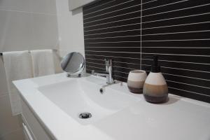 a bathroom sink with a mirror and two bottles on it at Casa do Pessegueiro in Mirandela +28 photos