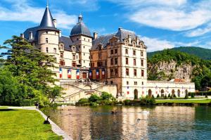 a large castle with a lake in front of it at Les Loges du Vercors in Vizille +1 photo