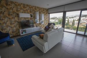 a living room with a white couch and a television at Casa do Pessegueiro in Mirandela