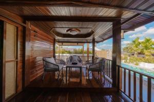 a screened porch with a table and chairs on a deck at Calisto Valley I Luxury Pool Villa Krabi in Ao Nam Mao