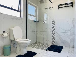a bathroom with a toilet and a shower at Maita Corner in Monte Vista +36 photos