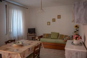 a living room with a table and a couch at Cav Costa degli Etruschi in San Vincenzo