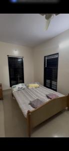 a bed in a room with two windows and a bedvisor at Offline Resort in Bengaluru, Karnataka
