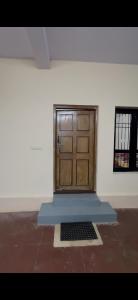 a large wooden door in a room with a window at Offline Resort in Bengaluru, Karnataka