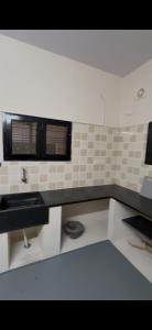 a white kitchen with a sink and a window at Offline Resort in Bengaluru, Karnataka