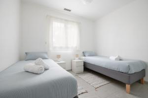 a bedroom with two beds and a window at Évasion à Bruguières in Bruguières