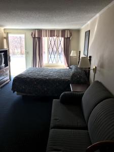a hotel room with a bed and a couch at Home Town Inn in Flint