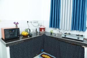 a kitchen with a counter top with a microwave at Induwara Beach Stay Thalalla in Delgalla