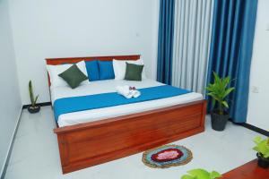 a bedroom with a bed with a stuffed animal on it at Induwara Beach Stay Thalalla in Delgalla