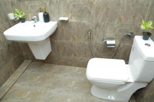 a bathroom with a white toilet and a sink at Induwara Beach Stay Thalalla in Delgalla