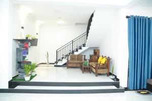 a living room with stairs and a blue curtain at Induwara Beach Stay Thalalla in Delgalla +16 photos