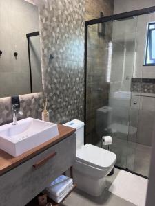 a bathroom with a toilet and a sink and a shower at Villa Pomerode Hospedagem - Suítes com conforto e aconchego conectados com a Natureza in Pomerode