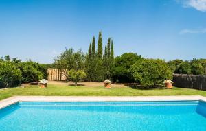 a swimming pool in front of a yard with trees at Can Polito in Can Picafort