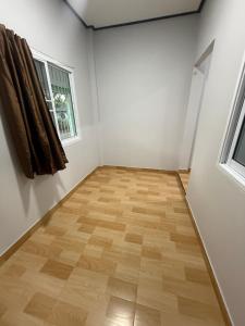 an empty room with a wooden floor and a window at Solara เฮ้าส์ in Ban Nong Saeng (4)