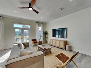 a living room with a couch and a flat screen tv at Gulf Place Spires #7B - Rum Cake in Santa Rosa Beach