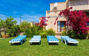 three blue benches sitting in the grass in front of a building at Etv4268, Casa Tolo in Son Servera