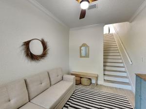 a living room with a couch and a staircase at Gulf Place Spires #7B - Rum Cake in Santa Rosa Beach +38 photos