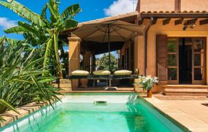 Ein Pool vor einem Haus mit einem Sonnenschirm in der Unterkunft Es Regaro in Capdepera + 39 Fotos