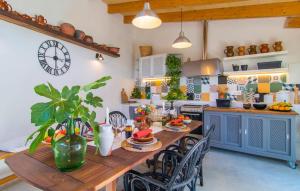 a kitchen with a wooden table with chairs and a clock at Casa Gema in El Port de la Selva +49 photos