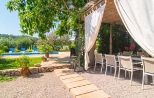 a table and chairs under a tent next to a pool at Can Sua in Artá