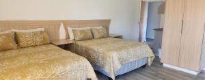 a hotel room with two beds and a cabinet at Riverside Inn in Oranjeville