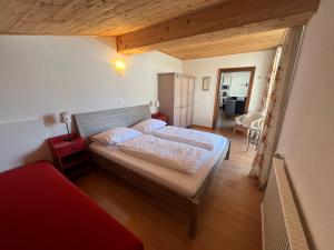 a bedroom with a large bed and a red couch at Schlossalm Appartement in Bad Hofgastein