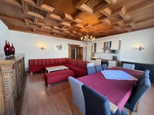 a living room with a red couch and a table at Schlossalm Appartement in Bad Hofgastein