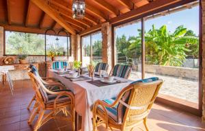 a dining room with a table and chairs and windows at Ca Na Conceda in Alcudia