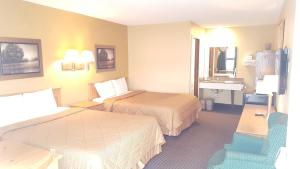 a hotel room with two beds and a sink at Oakdale Motel in Owatonna