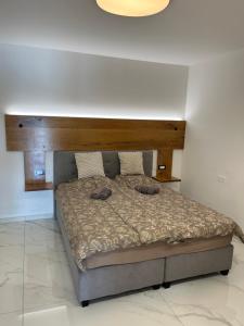 a bedroom with a large bed with a wooden headboard at Apartma Rozi Deluxe in Koper +15 photos