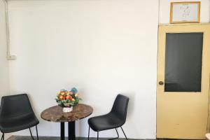 a table with a vase of flowers and two chairs at Toucan Garden in Samutprakarn +27 photos