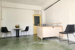 a room with three chairs and a cabinet and a table at Toucan Garden in Samutprakarn