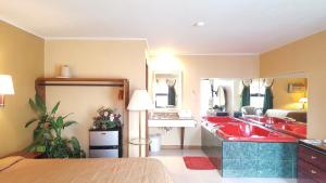 a bathroom with a red sink and a bedroom at Oakdale Motel in Owatonna +3 photos