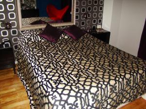 een slaapkamer met een bed met paarse kussens en een spiegel bij Lux Apartment in Lissabon