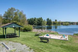 a park with two benches and a picnic table next to a lake at As You Wish by Railey Vacations in Oakland