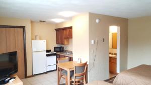 a small kitchen with a table and a refrigerator at Oakdale Motel in Owatonna