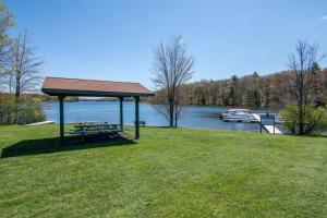 a picnic shelter on the grass next to a lake at As You Wish by Railey Vacations in Oakland