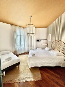 a large bedroom with two beds and a chandelier at Appartement ATHOS - Hyper Centre - Familiale in Orléans