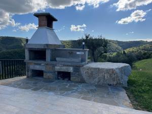 an outdoor fireplace on a patio with a rock at Apartma Rozi Deluxe in Koper
