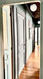 a hallway with an open door and a wooden floor at Appartement ATHOS - Hyper Centre - Familiale in Orléans