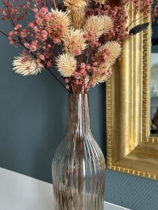 a clear vase with flowers in it on a table at Appartement ATHOS - Hyper Centre - Familiale in Orléans